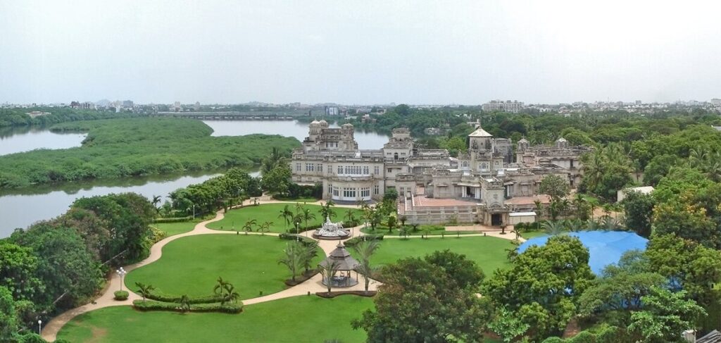 Aerial view of Chettinad Palace in Chennai surrounded by lush gardens and a nearby river