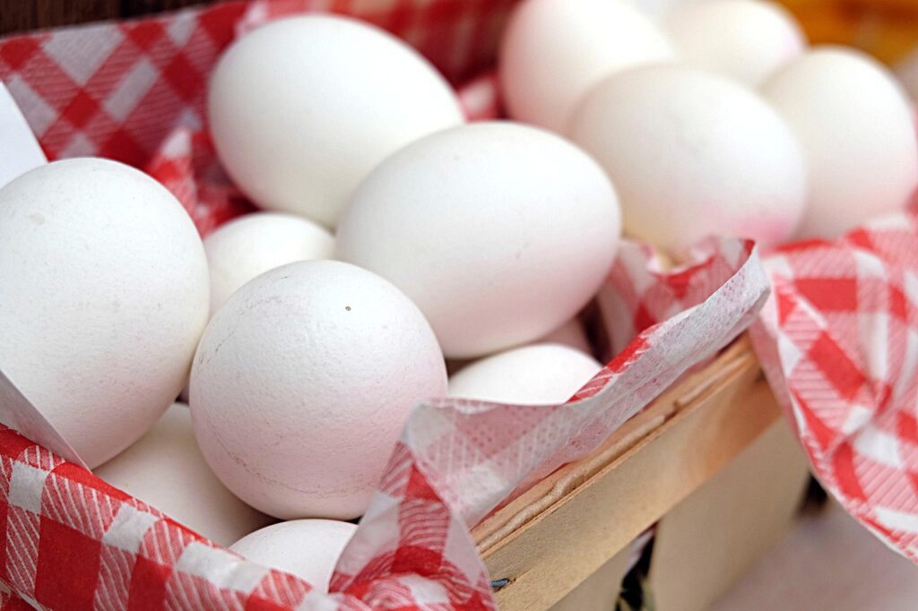 Fresh white eggs in a basket with red checkered cloth – a nutritious ingredient for healthy snacks for kids
