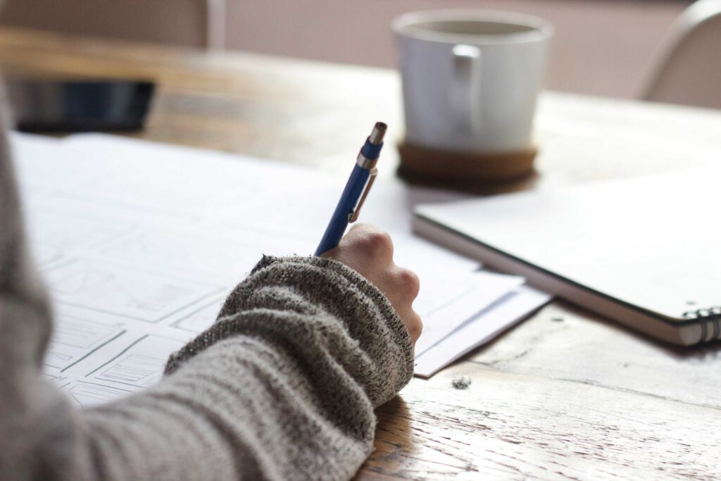 Person writing notes while learning how to start freelancing with no experience