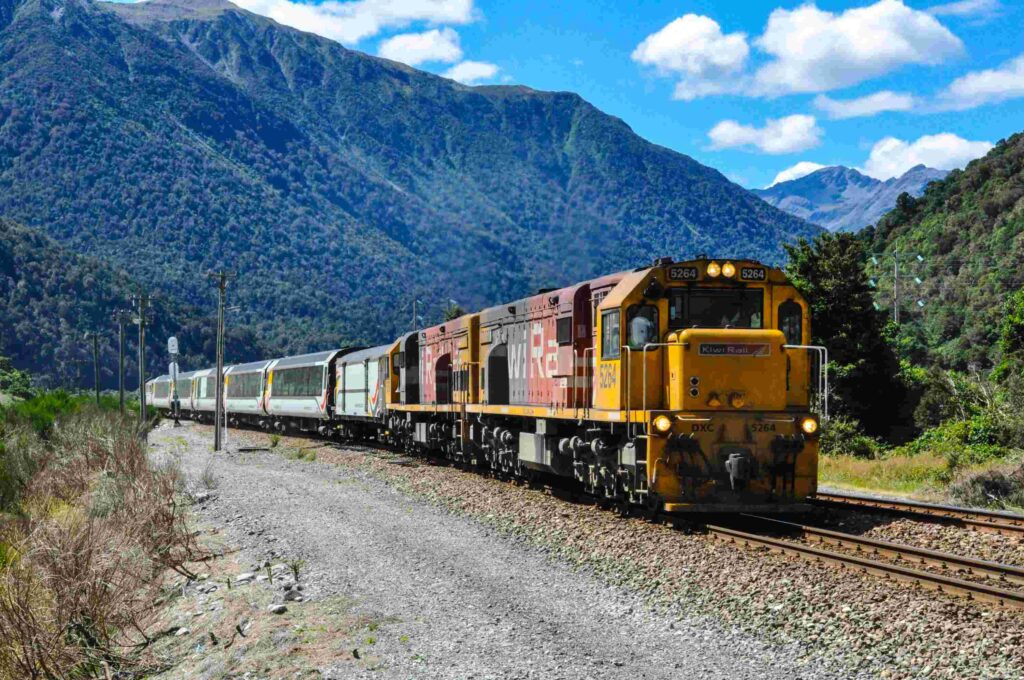 The TranzAlpine in New Zealand, one of the most scenic train rides in the world, traveling through the Southern Alps, lush rainforests, and deep river valleys.